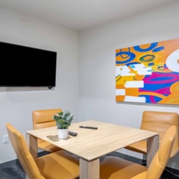 a room with a tv, table and chairs