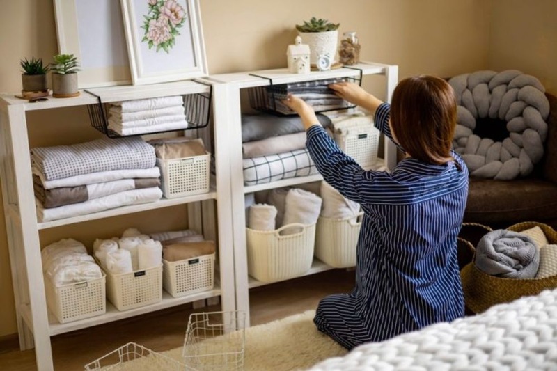 a person rearranging items on a shelf
