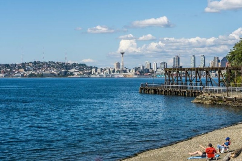 a body of water with a dock and a city in the background