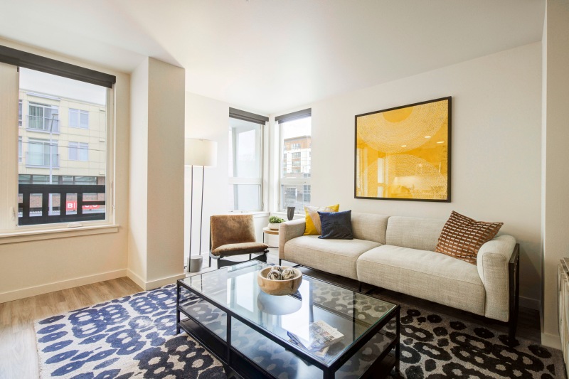 a living room with a large glass coffee table and a large window