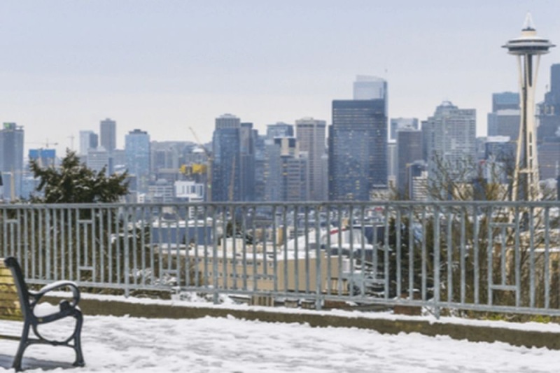 a bench overlooking a city and the Seattle space needle