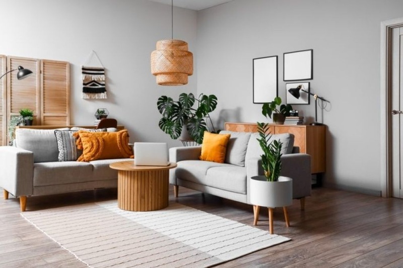Open space living area with a gray couch and orange pillows
