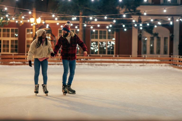 couple holding hands while ice skating